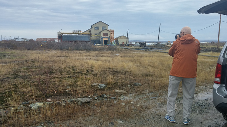 Christopher Pratt photographing a building in Buchans, Newfoundland, during his and Mirelle’s roadtrip.